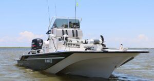 A sleek fishing boat is anchored in shallow waters. The boat features a powerful outboard motor and advanced fishing gear, ready for a fishing expedition.