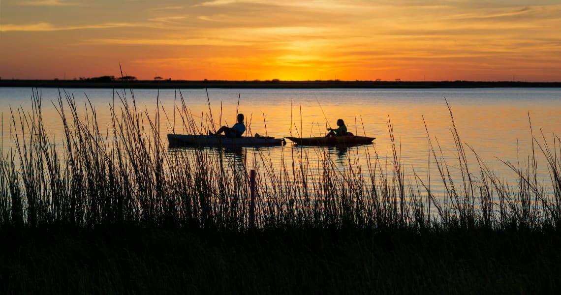 the-ultimate-guide-to-palacios-bay-beach-kayaking-5 People kayaking at sunset