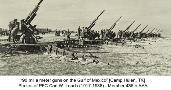 A black-and-white photograph showing a long line of large anti-aircraft guns positioned on the Gulf of Mexico at Camp Hulen, Texas. The guns are spaced evenly across the beach, with soldiers gathered around each one, preparing for or conducting an exercise. The image highlights the size and scale of the artillery, with several of the guns pointed skyward. The caption at the bottom reads, "90 millimeter guns on the Gulf of Mexico" along with a dedication to PFC Carl W. Leach, a member of the 435th AAA, and includes his years of life (1917-1988).